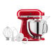 A red KitchenAid Artisan stand mixer with a silver bowl and white whisk attachment.