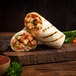 An Alpha Foods Chik'n Fajita burrito on a cutting board.