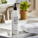 A white bottle of Grey + Finch DoveLok shampoo on a counter.