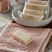 A white rectangular bar of FarmHouse Fresh Botanical Blend soap on a pink surface.