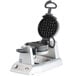 A Waring double Belgian waffle maker with a black handle and round waffle plates.