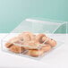A clear Cal-Mil food bin with bagels inside on a bakery display counter.