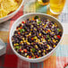 A bowl of black beans and corn on a table.