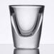 A close-up of a Libbey shot glass with a curved bottom on a table.