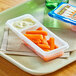 A white tray with baby carrots and ranch dip.