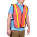 A man wearing a Cordova orange high visibility safety vest with reflective tape.