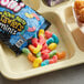 A table with a tray of Trolli Mini Sour Brite Crawlers pouches.