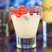 A Libbey customizable rocks glass filled with white liquid and raspberries.