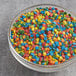 A bowl of Mini Bold Confetti Sprinkles on a table.