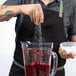 A man pouring sugar into a Breville Commercial blender.