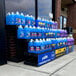 A Benchmaster three step display with blue containers of car wash cleaner on an outdoor sidewalk.