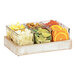 A white-washed wood Cal-Mil condiment organizer tray with glass containers of fruit.
