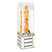 A Cal-Mil beverage dispenser with oranges and lemons in the infusion chamber on a white and gold metal base.