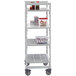 A white Cambro Premium Camshelving unit with gray vented shelves and plastic containers of food on it.