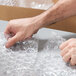 A person's hand holding a box of Lavex medium bubble wrap.