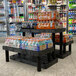 A black plastic Benchmaster end cap display with three shelves of soda bottles.