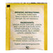 A yellow Twinings packet with black text and a yellow and white label with black text for Twinings Lemon & Ginger Herbal Tea Bags.