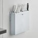 A white plastic wall mount knife rack with knives in it.