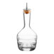 A clear glass Barfly bitters bottle with a cork stopper.