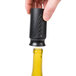 A hand holding a Franmara black wine saver vacuum pump over a yellow bottle of wine.