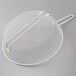 A white wire mesh Thunder Group breading basket with a handle.
