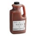 A jug of brown Dona Original Masala Chai liquid with a white label.