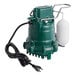 A green and black Zoeller M53 sump pump with a white plastic tube.