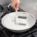 A hand using a spatula to stir a Vollrath Wear-Ever non-stick fry pan on a stove.