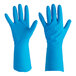 A hand wearing a blue Ansell AlphaTec nitrile glove with a lozenge grip.