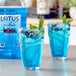 A glass of blue Lotus Plant Energy concentrate with berries and mint.
