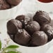 A bowl of chocolate balls on a counter.