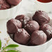 A bowl of Guittard French Vanilla dark chocolate truffles on a counter.