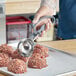 A person using a Choice Gray EZ Grip Squeeze Handle Disher to make meatballs.