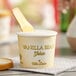 A Villa Dolce Vanilla Bean Gelato cup with a wooden spoon inside.