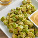A plate of fried Savor Imports cut okra with dipping sauce.