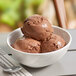 A bowl of Villa Dolce Dark Chocolate Gelato on a table with a spoon.