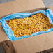A blue box with a bag of Simplot RoastWorks flame-roasted corn inside.
