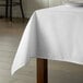 A white Intedge rectangular tablecloth on a table.