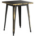 A black and gold metal Lancaster Table & Seating outdoor dining table.
