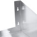 A close-up of a metal corner on an Advance Tabco stainless steel wall mount shelf with holes.