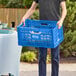 A person holding a blue plastic Choice crate.