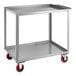 A silver metal Lavex utility cart with red wheels.