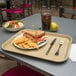 A Carlisle beige plastic fast food tray with a sandwich and chips on it.