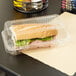 A sandwich in a Duralock clear hinged lid plastic container.
