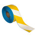 A roll of yellow and white striped Superior Mark safety tape.