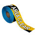 A roll of black and yellow striped Superior Mark safety tape with the words "Keep Area Clear" on it.