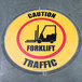 A Superior Mark clear round floor sign protector with a caution forklift sign inside.