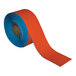A roll of orange tape with blue and orange packaging.