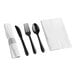 A close-up of a black fork, knife, and spoon set with a white napkin.
