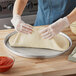 A person in gloves using a Choice deep dish pizza pan to make pizza dough.